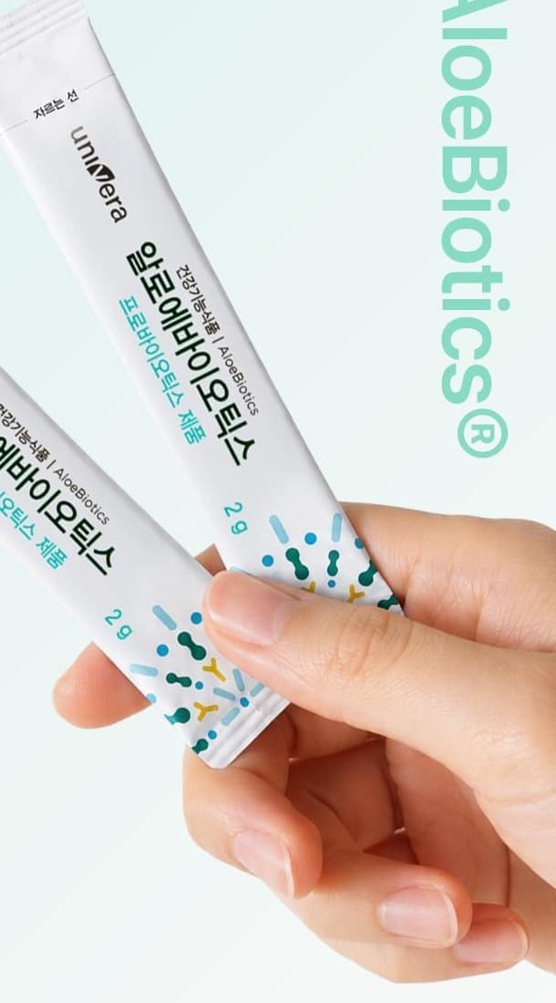 손에 쥔 알로에바이오틱스 스틱 2포, 오른쪽에 AloeBiotics® 글자
