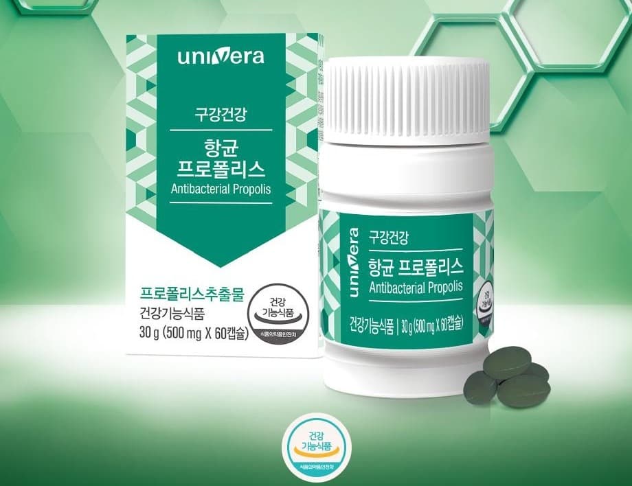 육각 벌집 무늬의 초록 배경 앞에 놓인 항균 프로폴리스 박스와 병, 진녹색 캡슐 3알