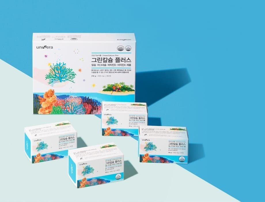 파랑 종이 위 그린칼슘 플러스 큰 상자(건강기능식품 | GreenCalcium Plus · 칼슘·마그네슘·비타민D·비타민K 제품 · 216 g | 600 mg x 360정)와 작은 상자 넷