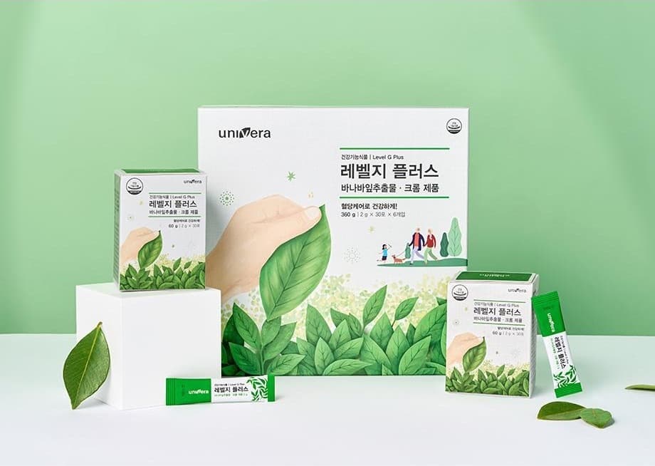 연두 벽 앞 흰 받침 위의 레벨지 플러스 360 g 큰 상자(360 g | 2 g × 30포 × 6개입)와 60 g 작은 상자 둘, 스틱 둘, 잎
