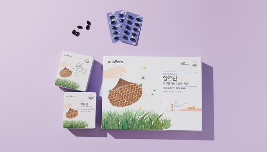 연보라 바닥 위의 알로신 270 g 큰 상자와 45 g 작은 상자 둘(건강기능식품 | Alosin · 알로신 · 프로폴리스추출물제품 · 건강하고 활기찬 생활을 위하여!), 캡슐이 든 보라 블리스터 둘과 낱개 캡슐